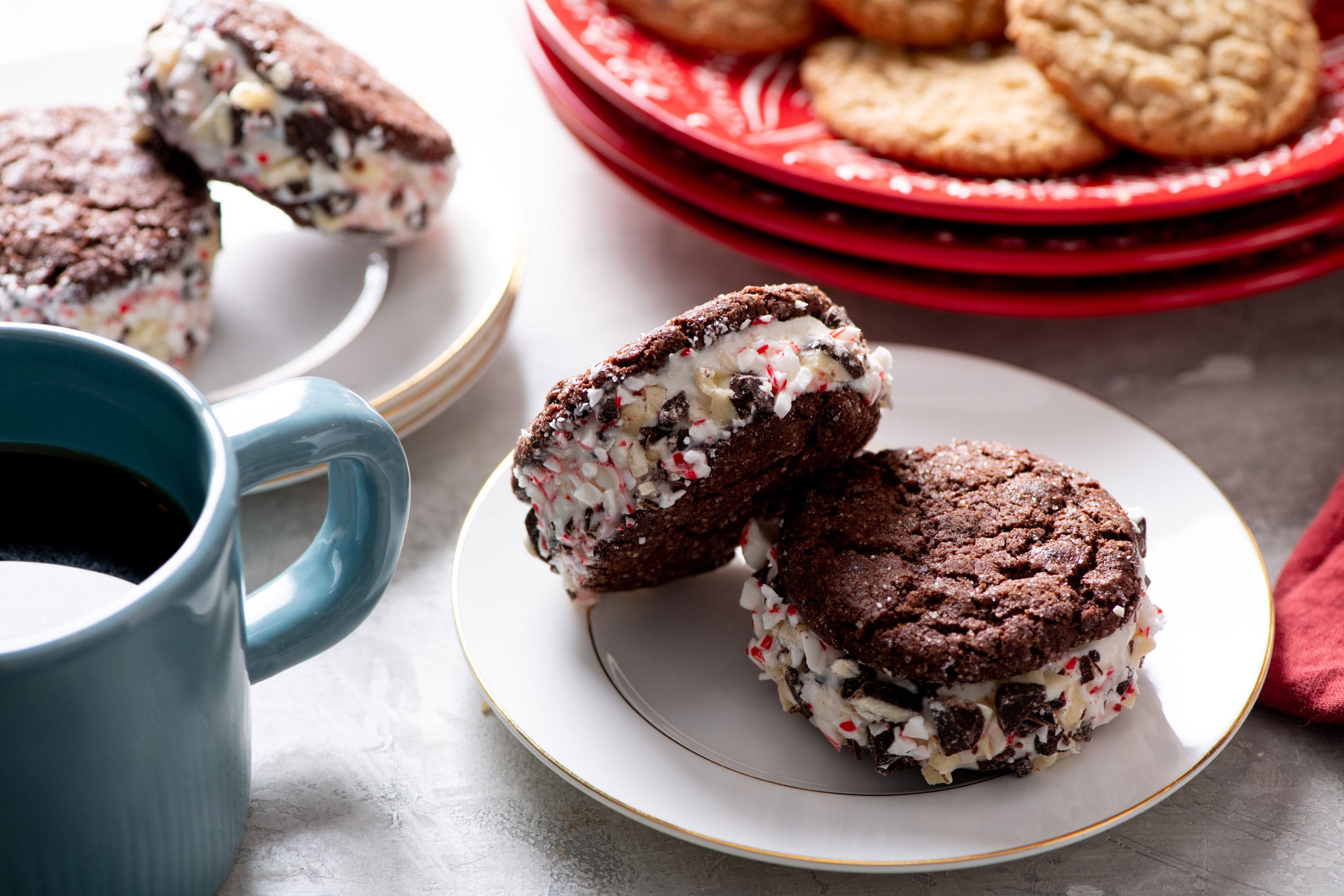 Two chocolate cookie ice cream sandwiches on a plate.