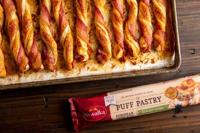 Herbed Cheesy Puff Pastry Bacon Straws next to a container of Wewalka puff pastry.