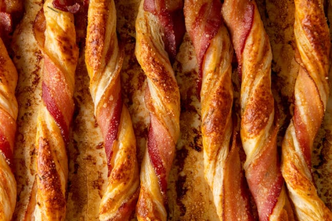 Herbed Cheesy Puff Pastry Bacon Straws on a lined baking sheet.