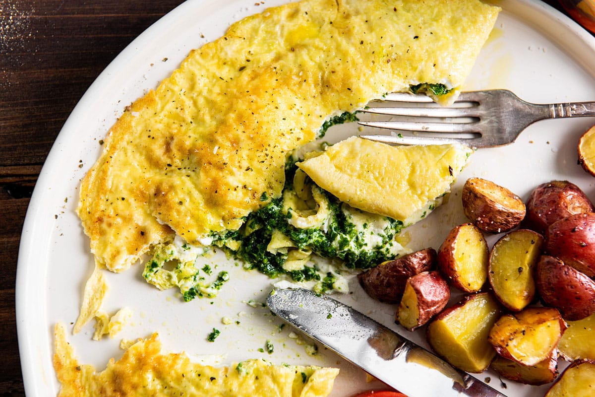 Eating Kale Pesto and Goat Cheese Omelet with fork.