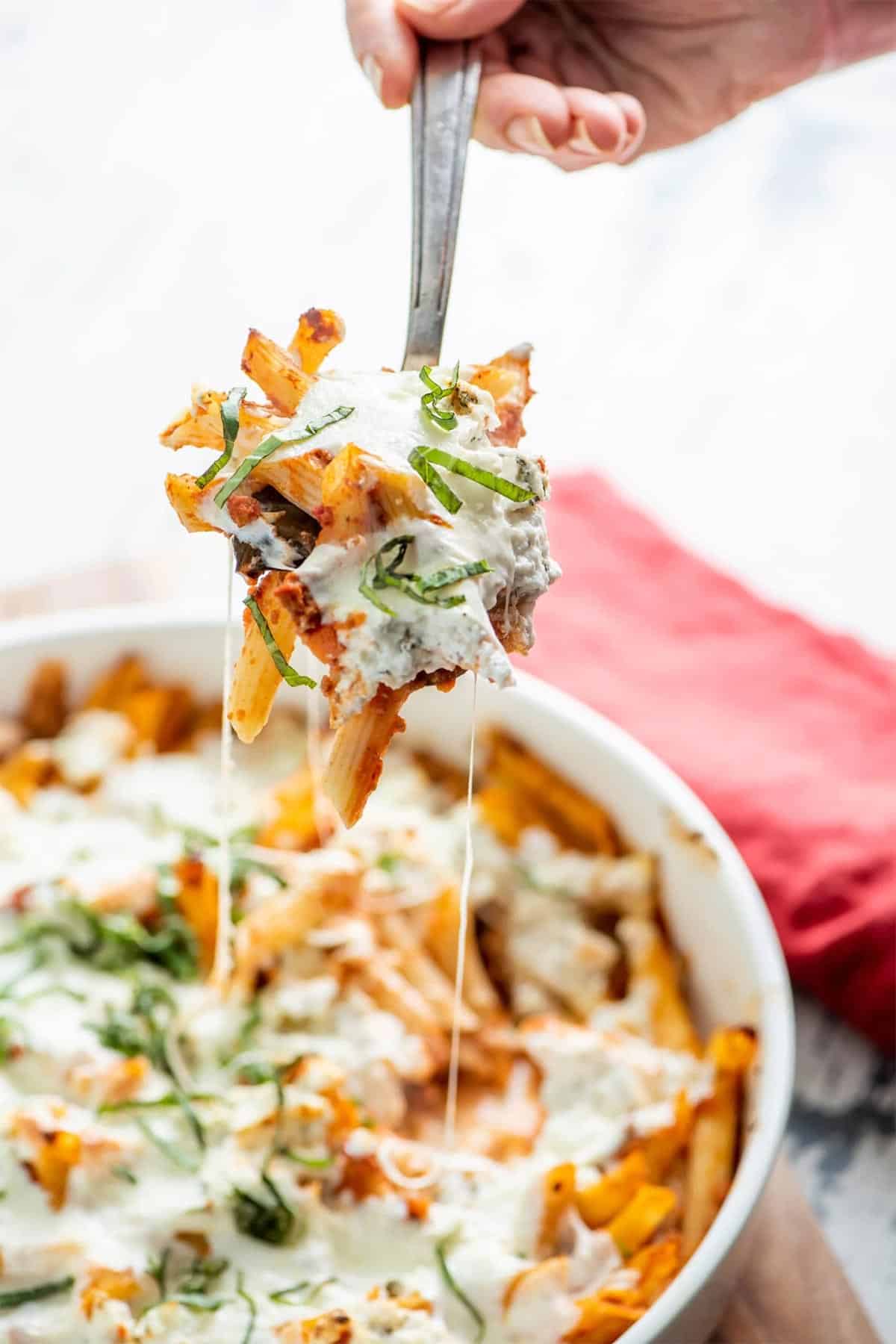 Spoon serving Baked Pasta with Bolognese Sauce.