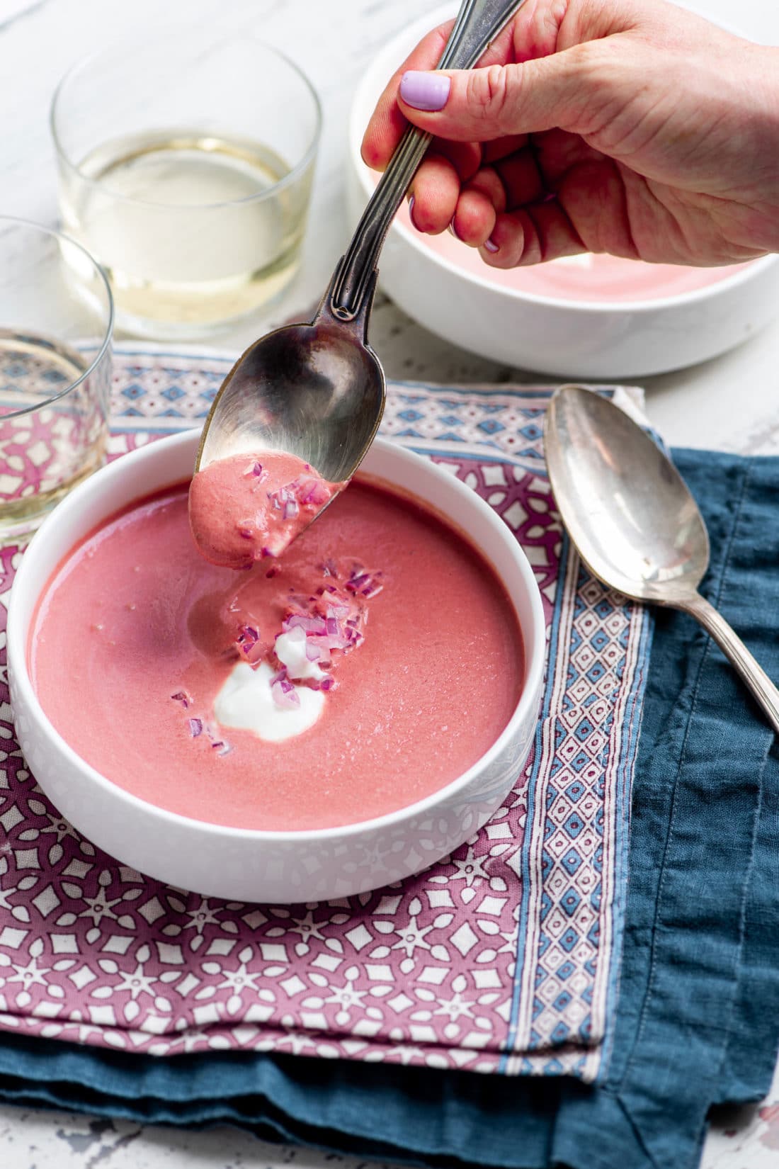 Spoon scooping Creamy Roasted Beet Soup from a bowl.