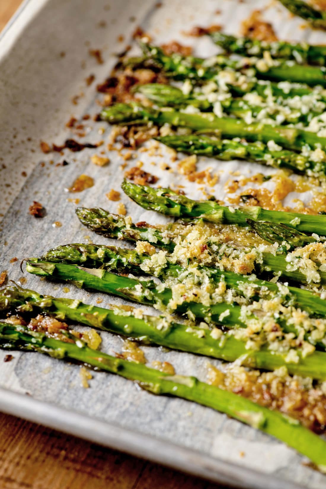Garlicky Roasted Asparagus with Parmesan on parchment paper.