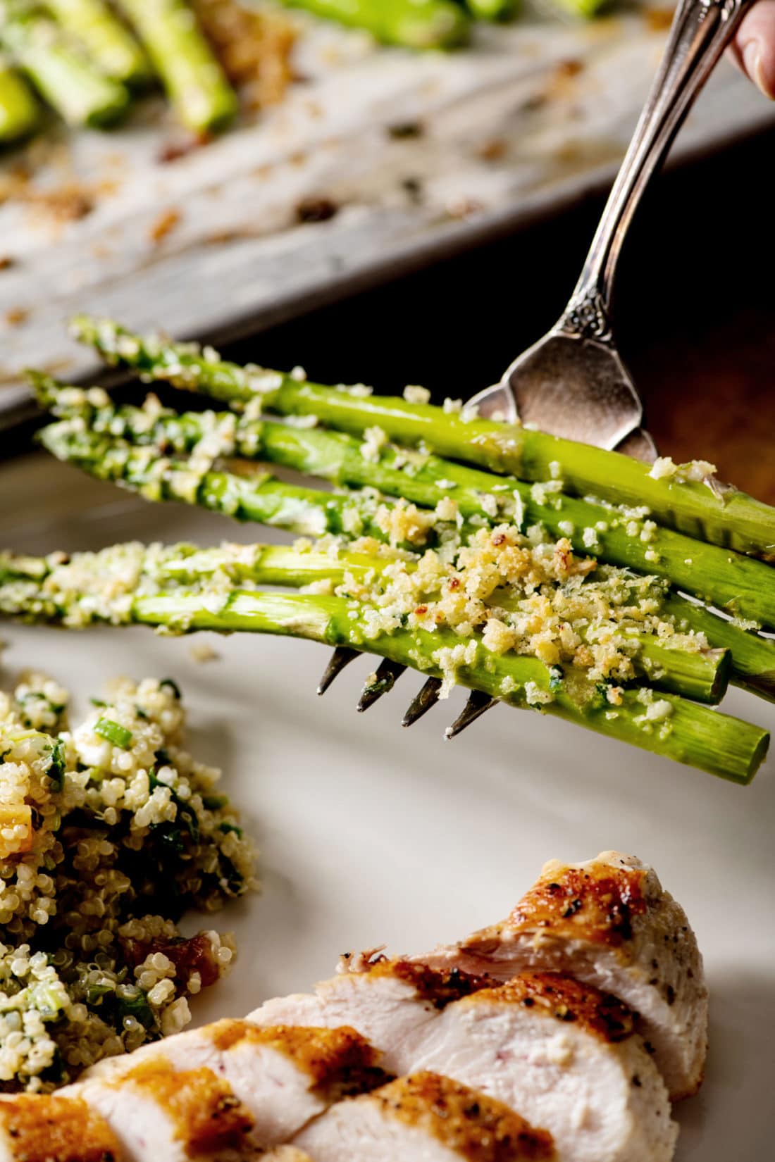 Fork holding some Garlicky Roasted Asparagus with Parmesan.