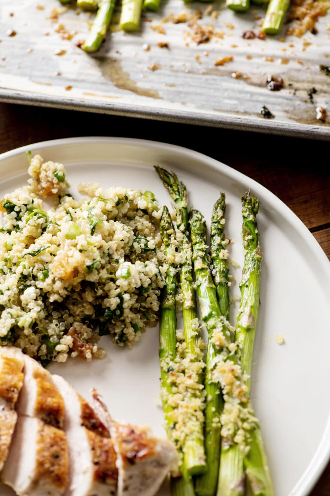 Garlicky Roasted Asparagus with Parmesan on a plate with meat and grains.
