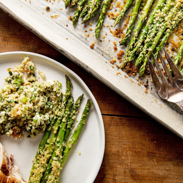 Garlicky Roasted Asparagus with Parmesan on a plate and a serving platter.