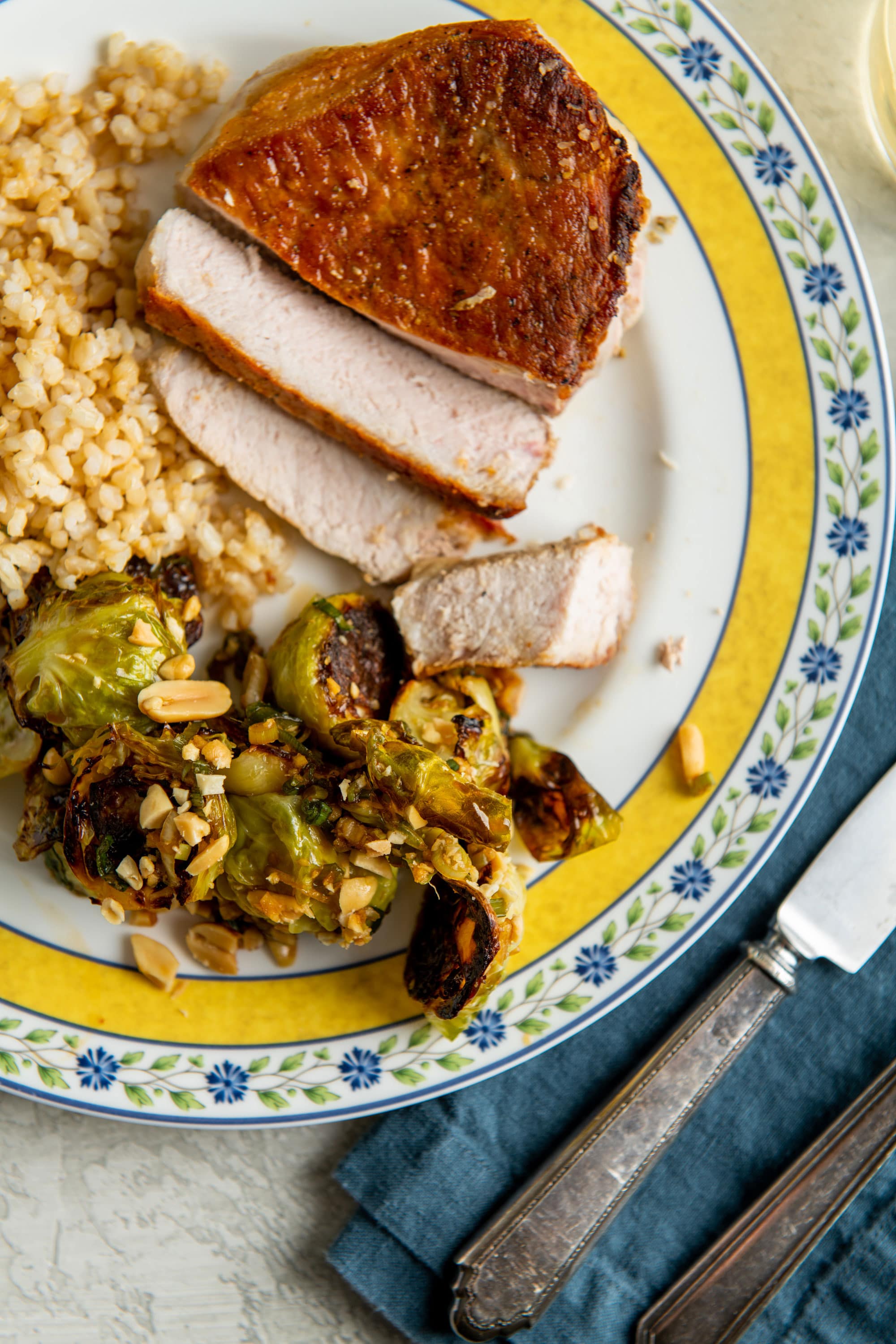 Kung Pao Brussels Sprouts next to sliced pork chop.