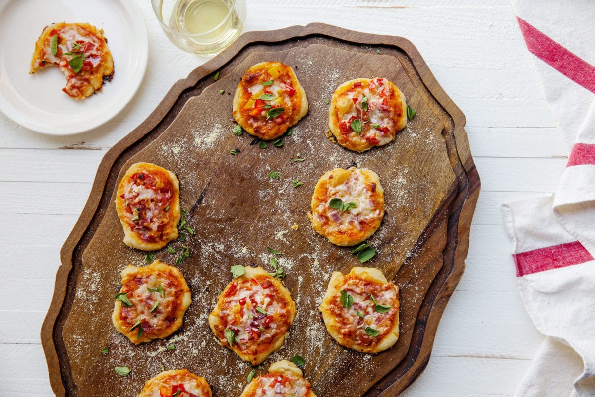 Mini Pizzas on a wooden surface.