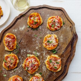 Mini Pizzas on a wooden surface.