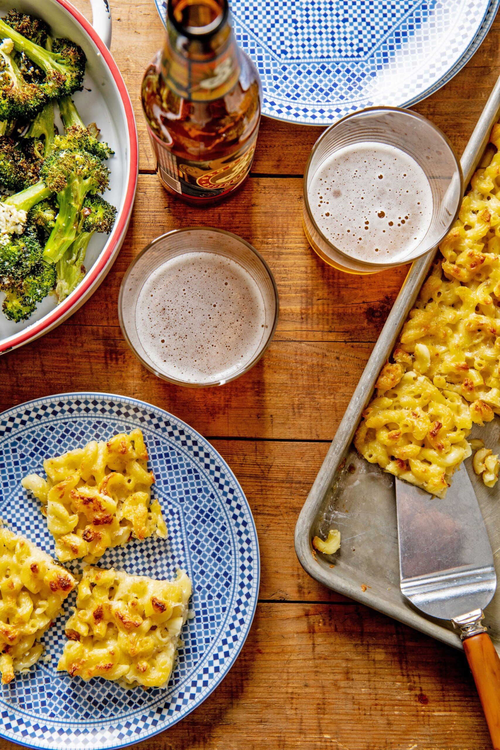 Tabel set with Sheetpan Macaroni and Cheese Squares, broccoli, and beer.