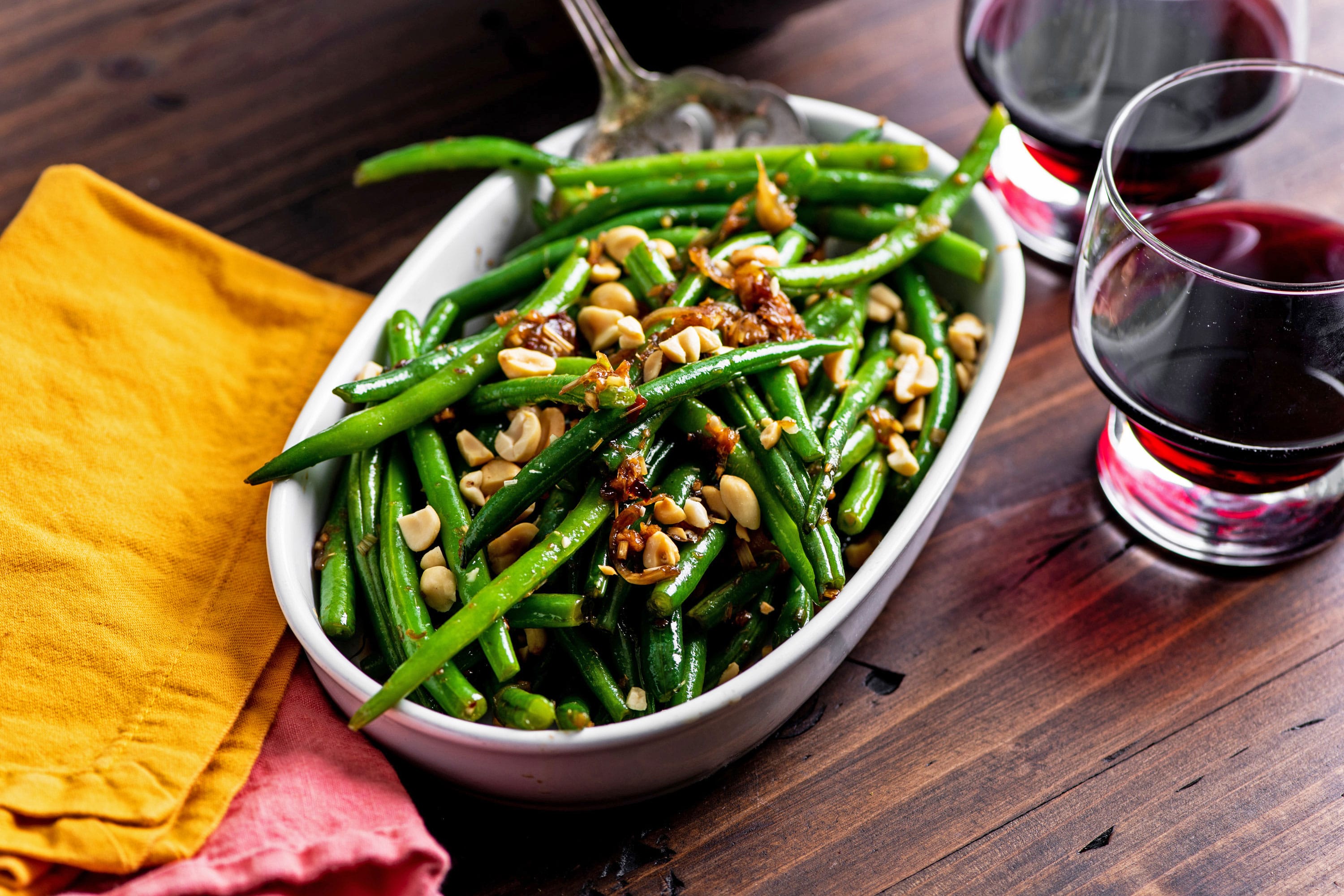 Oblong dish of Thai Green Beans topped with peanuts.