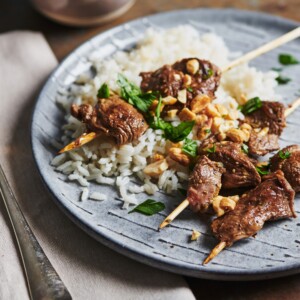 Lamb Satay and rice on a plate.