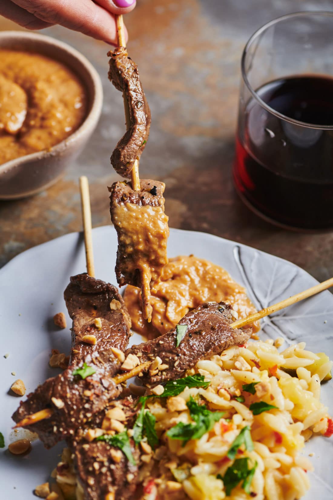 Lamb Satay skewer dipped in peanut sauce.