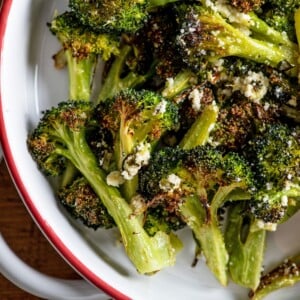 Red and white bowl of Parmesan Roasted Broccoli.