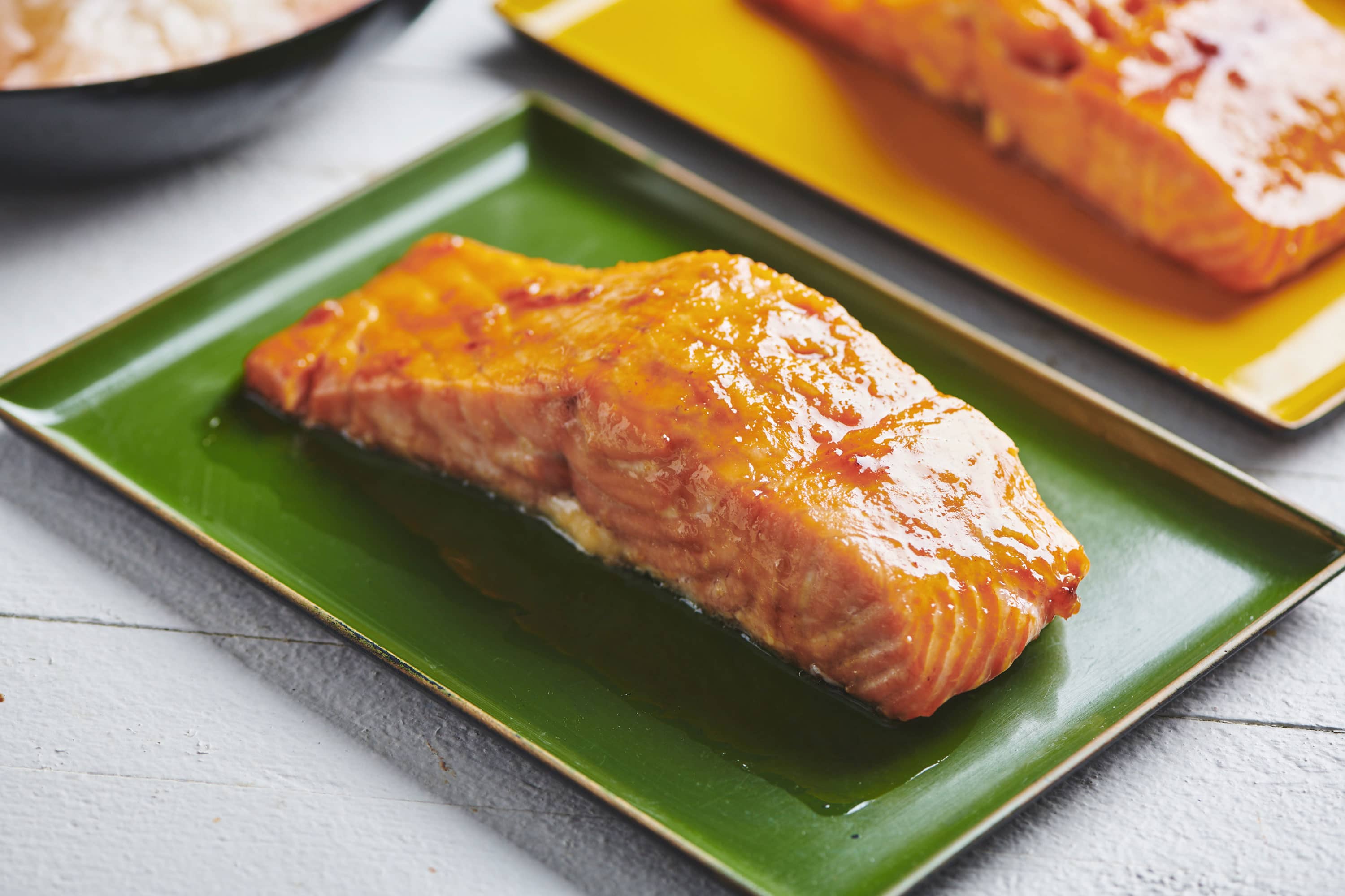 Honey and ginger glazed salmon filets on plates.