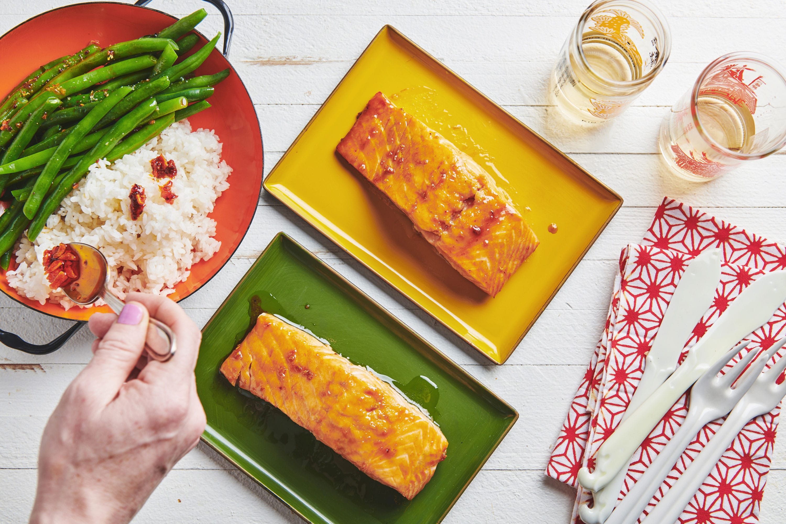 Honey Ginger Salmon on plates near a plate of rice and green beans.