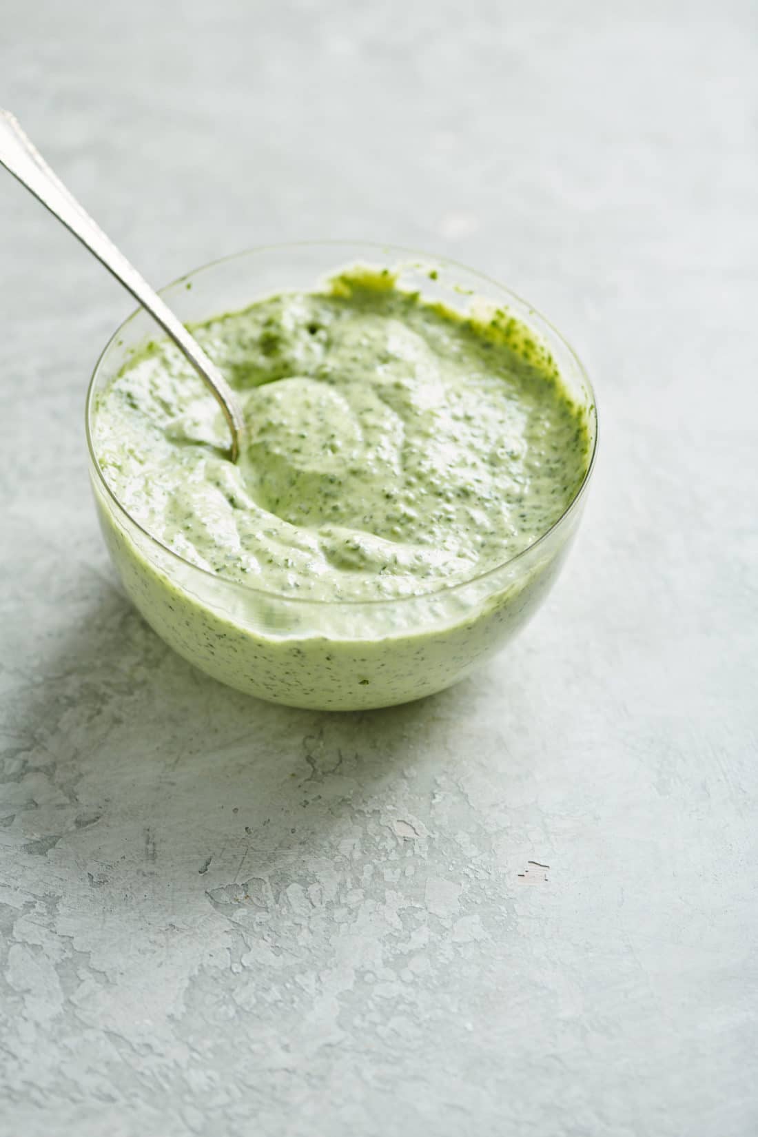 Spoon in a bowl of Herbed Mayonnaise.