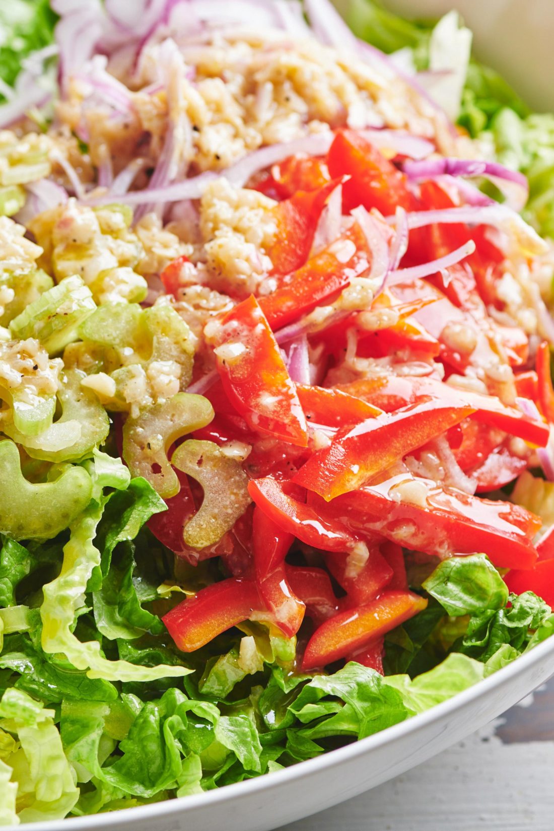 Romaine Salad topped with red onion, red bell pepper, and celery.
