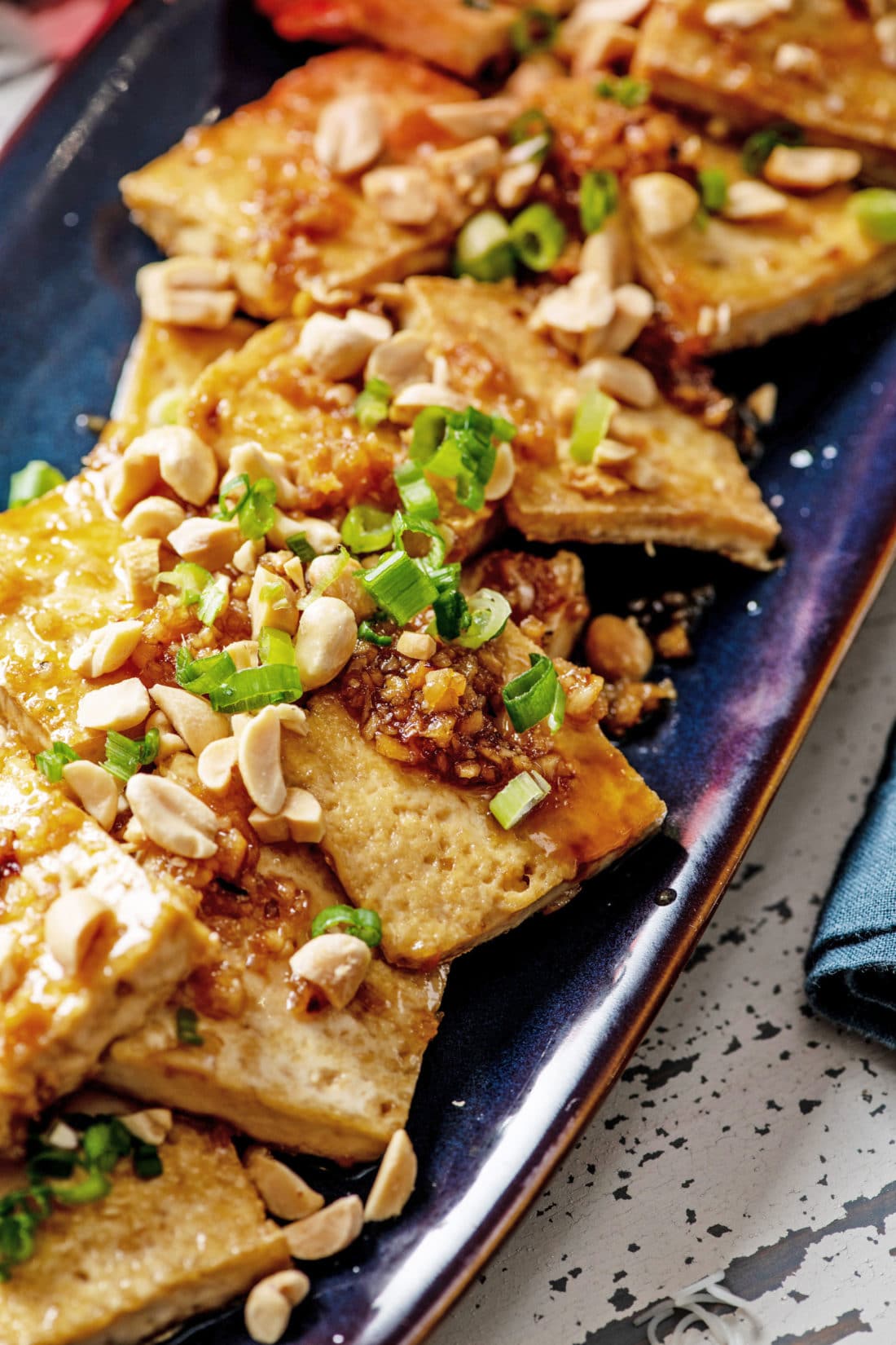 Spicy, Sweet and Nutty Tofu on a blue platter.