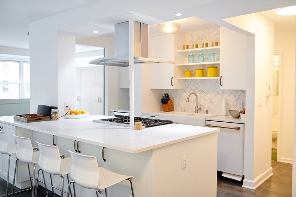 Clean, white kitchen with appliances, knives, and decorations.
