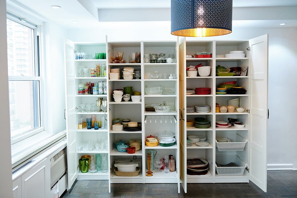 Pantry filled with dishes, glassware, and serving-ware of various colors and sizes.