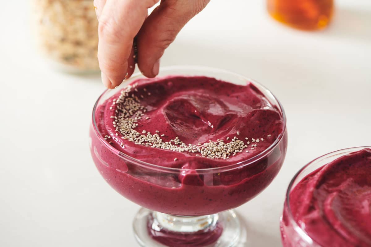 Sprinkling chia seeds on Beet Berry Smoothie Bowl