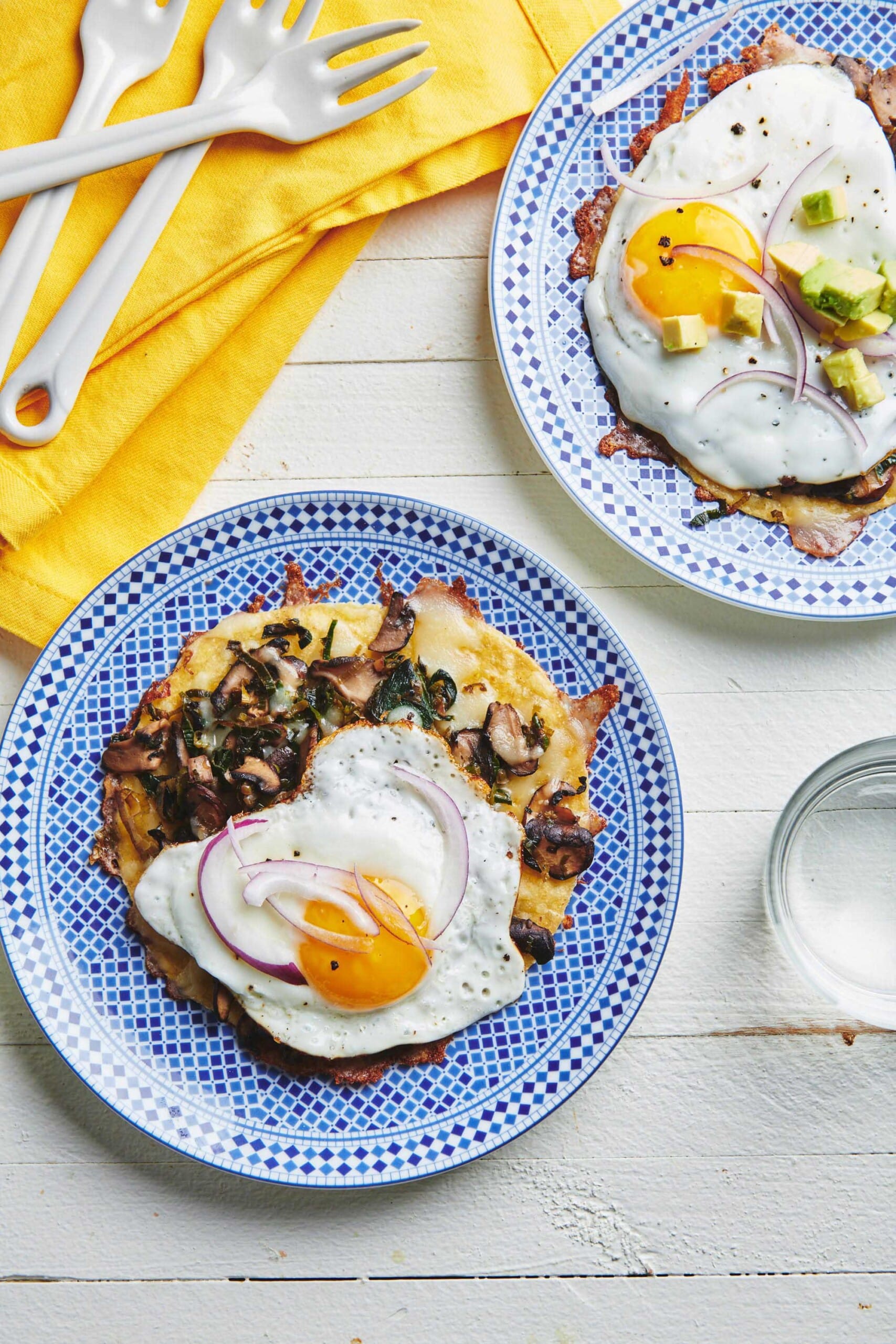 Fried Egg, Mushroom, Leek, and Cheese Tostadas on blue and white plates.