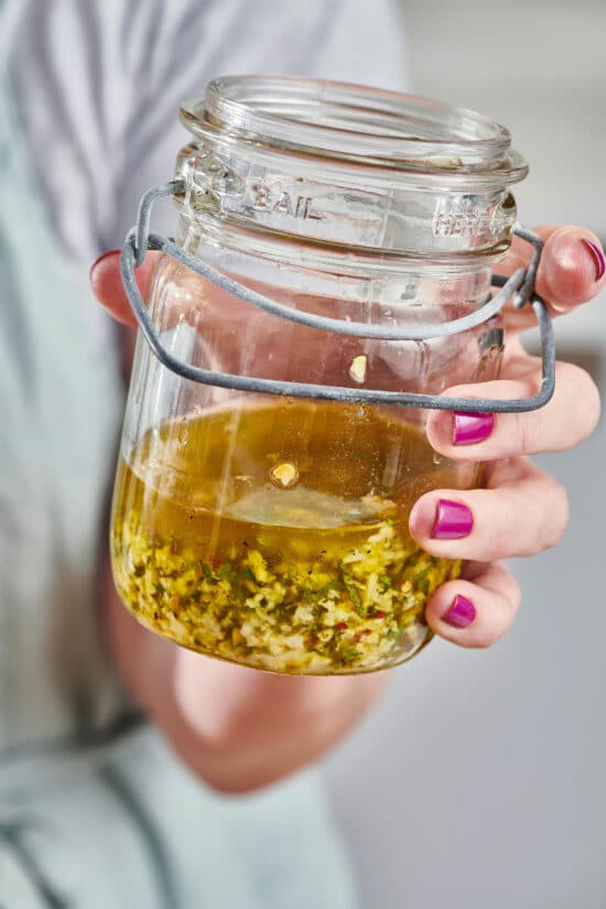 Woman holding a jar of Ginger, Mint, and Lime Marinade.