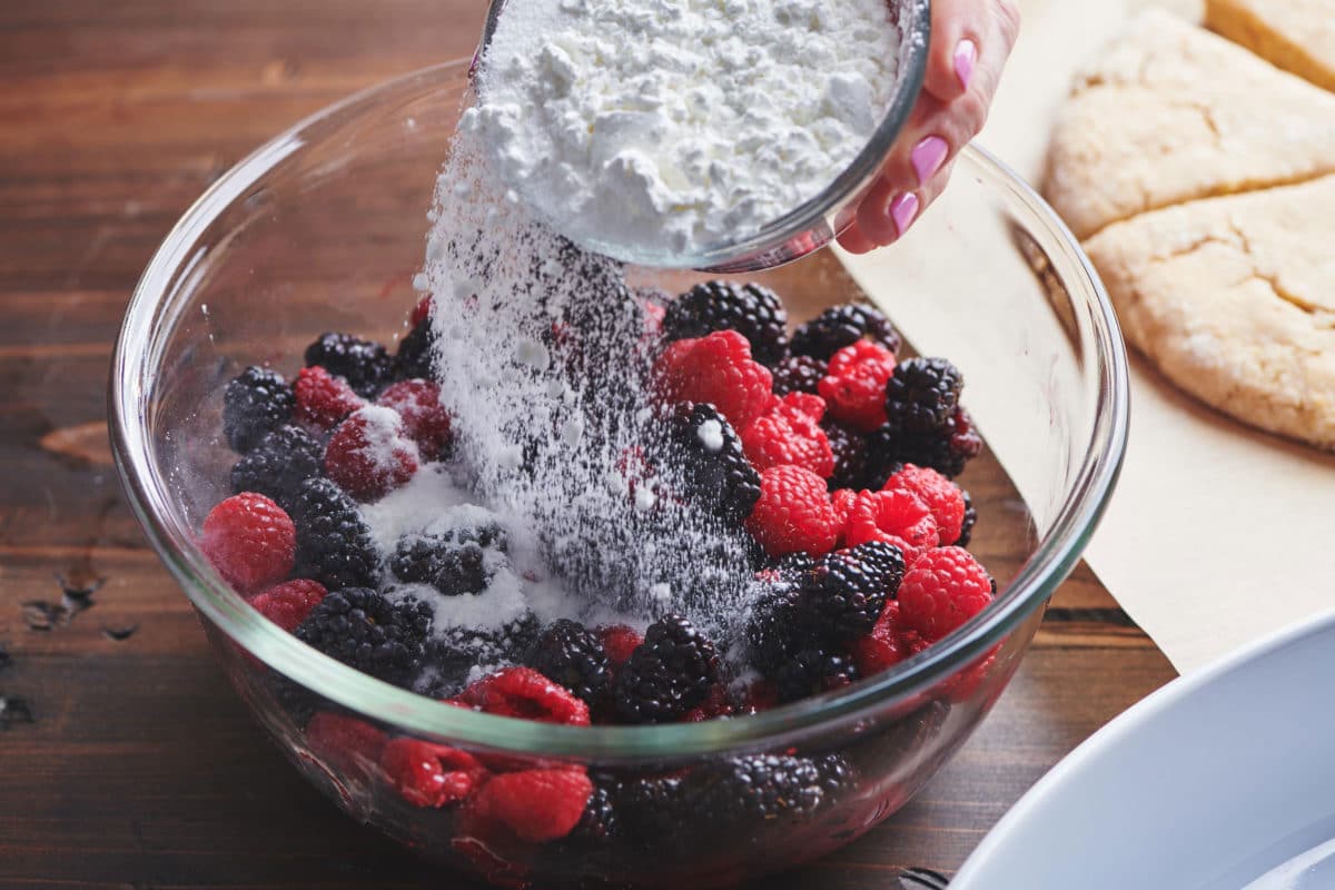 Sprinkling sugar over blackberries and raspberries