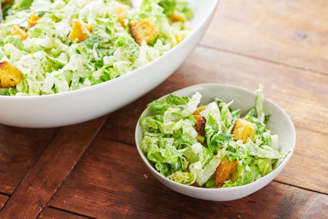 Caesar Salad with Garlicky Croutons in a large bowl and a small bowl.
