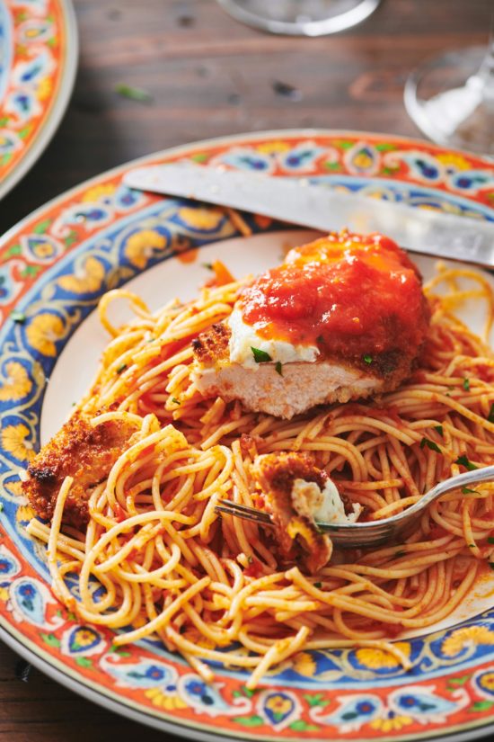 Chicken Parmigiana on a plate with spaghetti