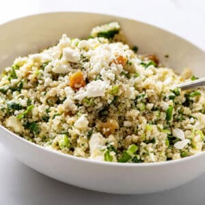 Kale Quinoa Salad with Honey, Lemon and Dijon Dressing in large white serving dish with spoon.