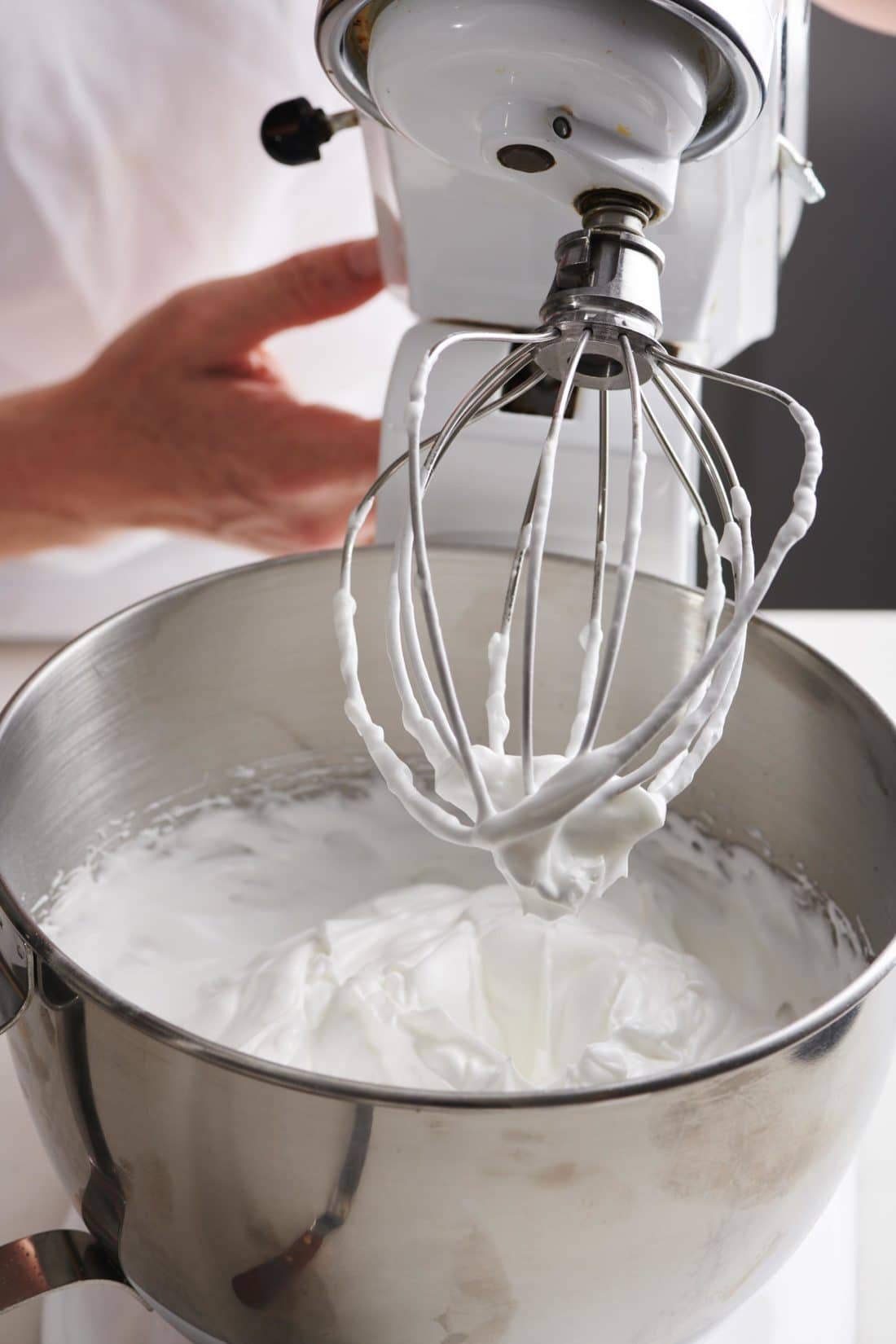 Electric beater with a bowl of meringue.