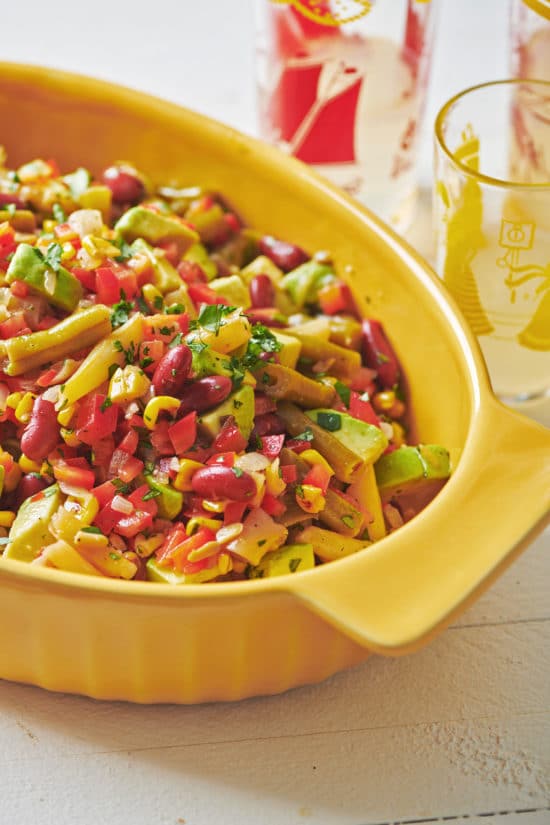 Mexican Avocado, Corn and Three Bean Salad in a yellow bowl.