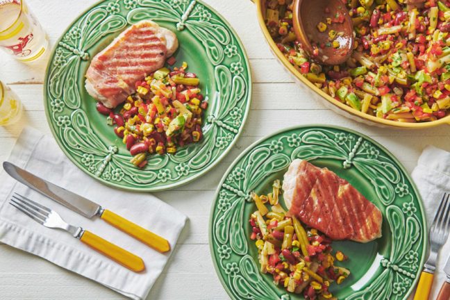 Plates of Mexican Avocado, Corn and Three Bean Salad and meat.