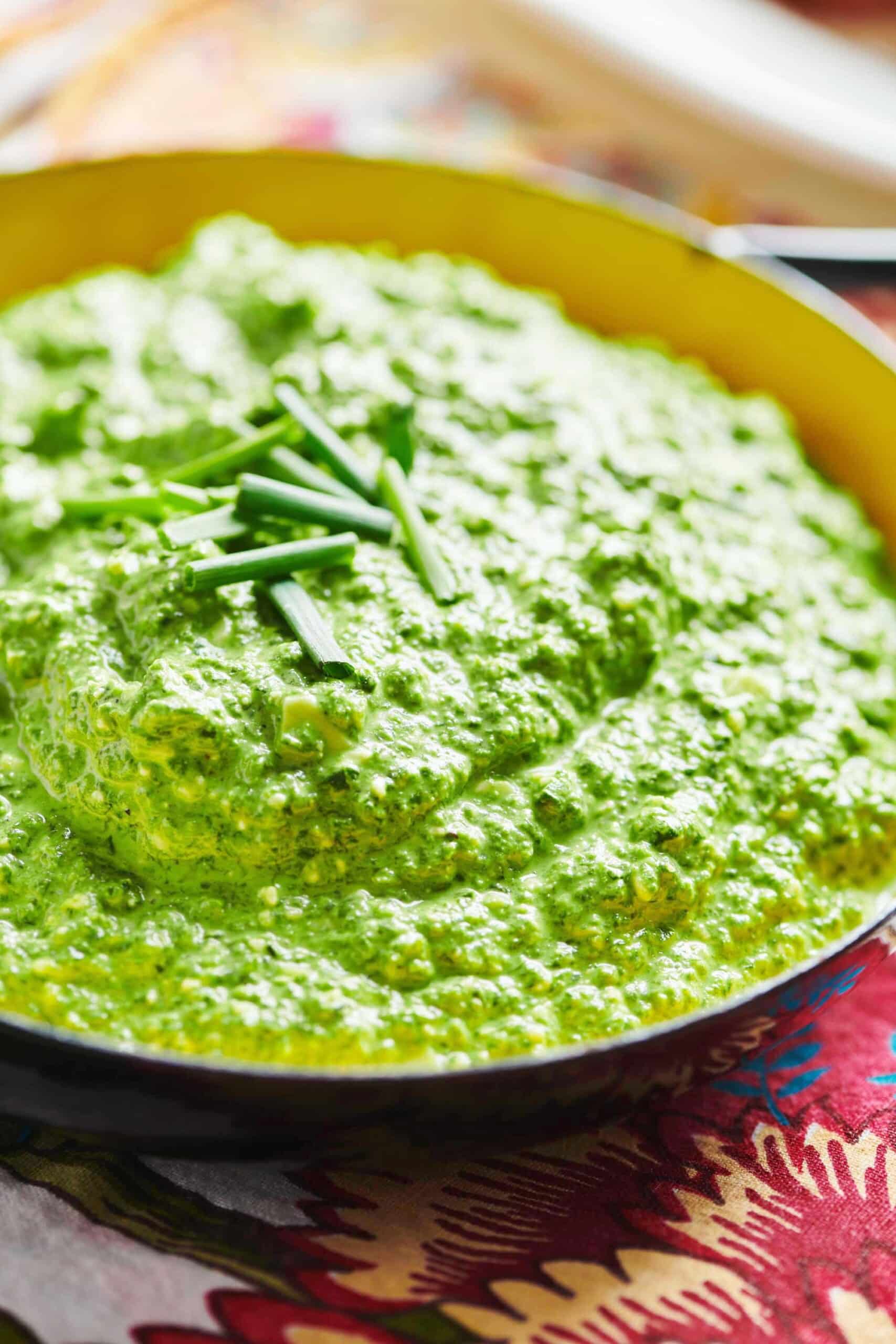 Parmesan Feta Spinach Dip in a bowl with chives on top