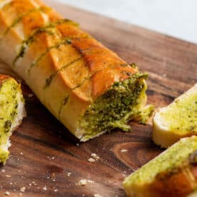 Garlic Bread filled with persillade sauce on cutting board.
