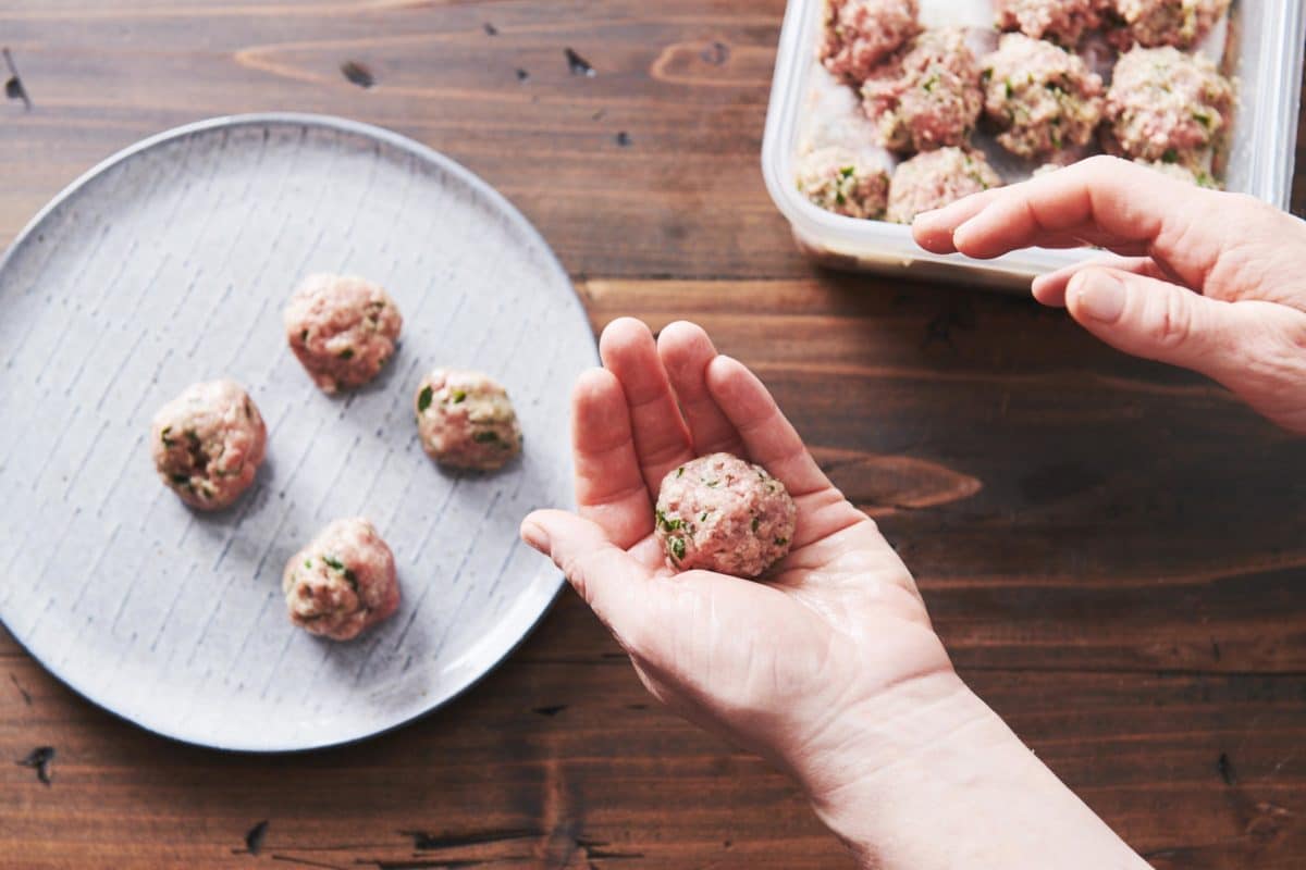Woman forming Swedish meatballs in her hand.