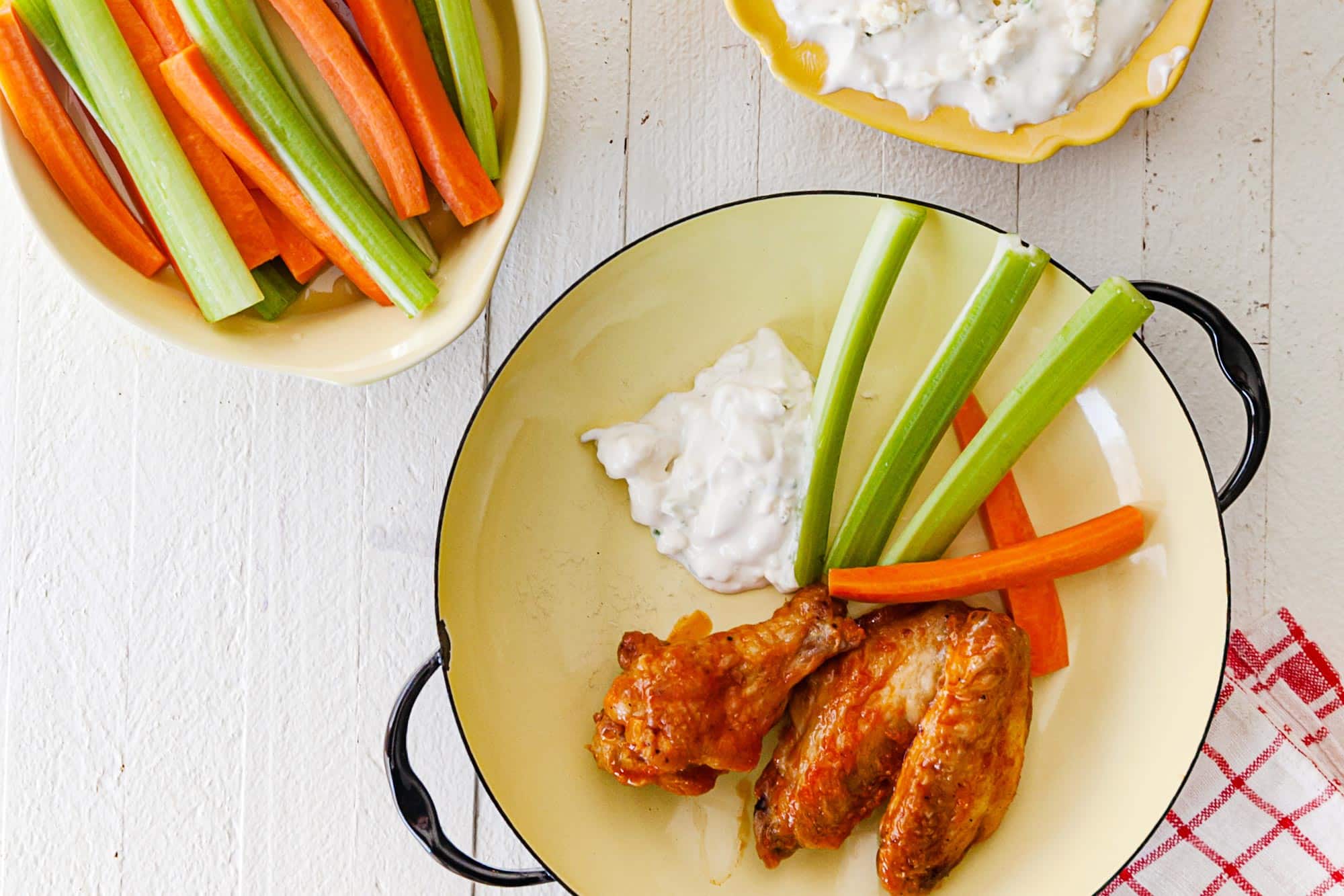 Air Fryer Buffalo Chicken Wings on a yellow plate with celery, carrots, and some blue cheese dip.