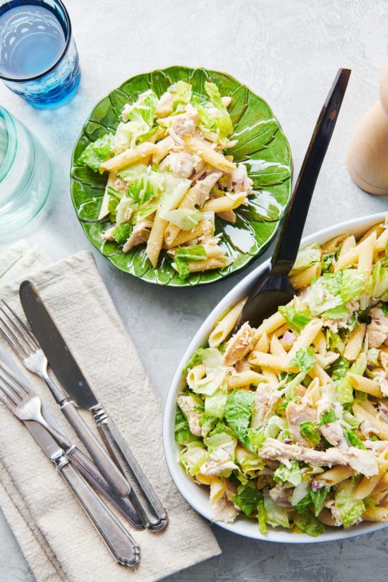 Green plate and white bowl of Chicken Caesar Pasta Salad.