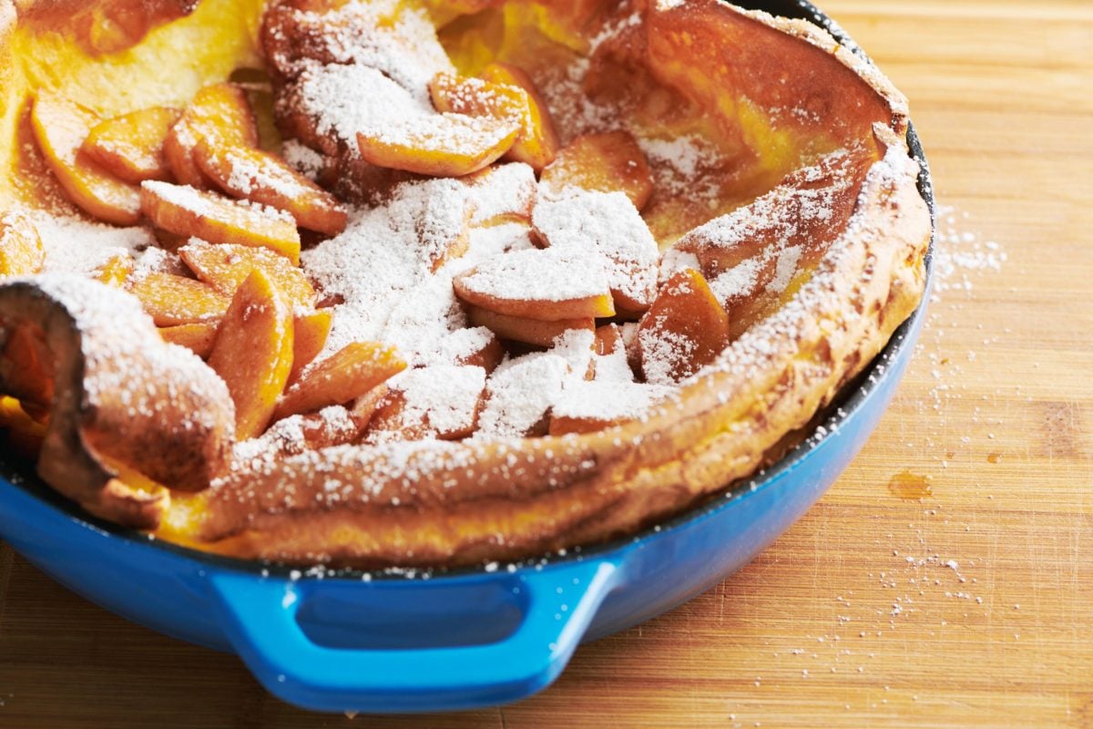 Dutch Baby Pancake with Sauteed Apples topped with powdered sugar.