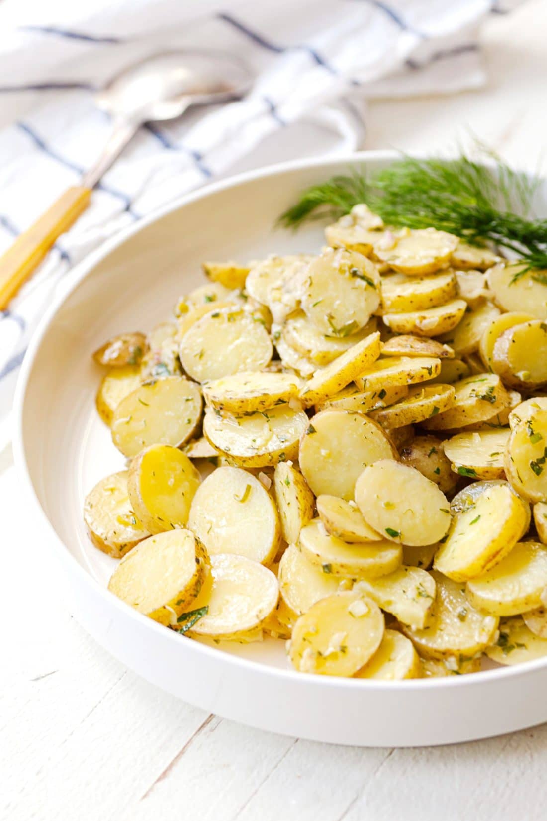 French Potato Salad piled in a large white bowl.