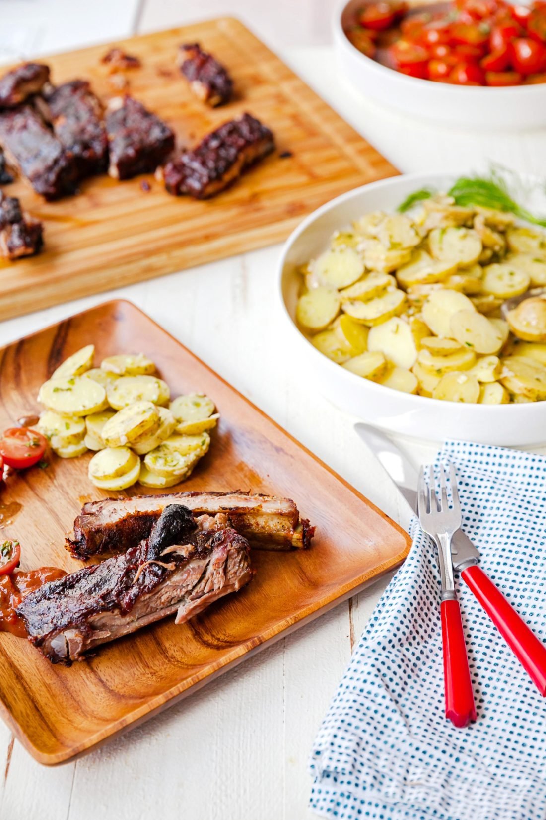 French Potato Salad on a wooden plate and in a large bowl.