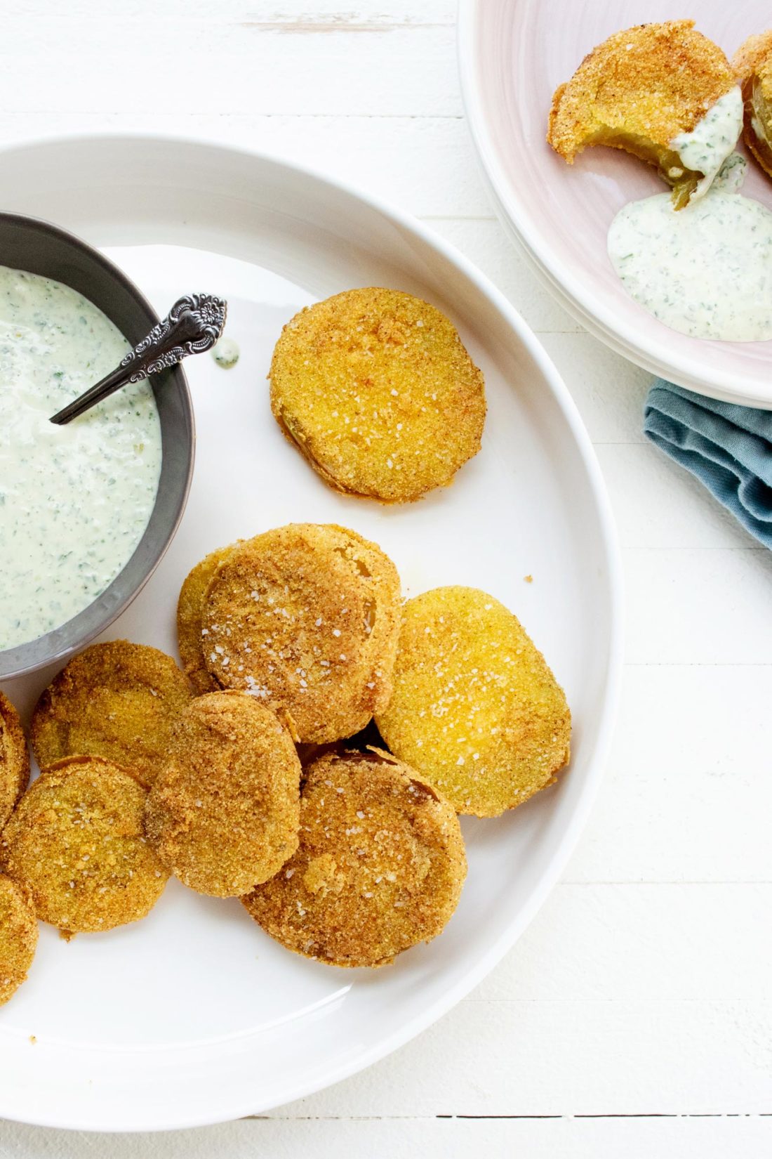 Fried Green Tomatoes on a plate with a bowl of Green Goddess Dressing.
