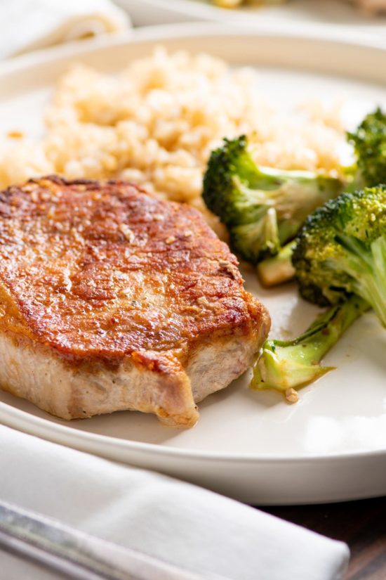 Garlicky Pork Chops and Broccoli on white serving plate