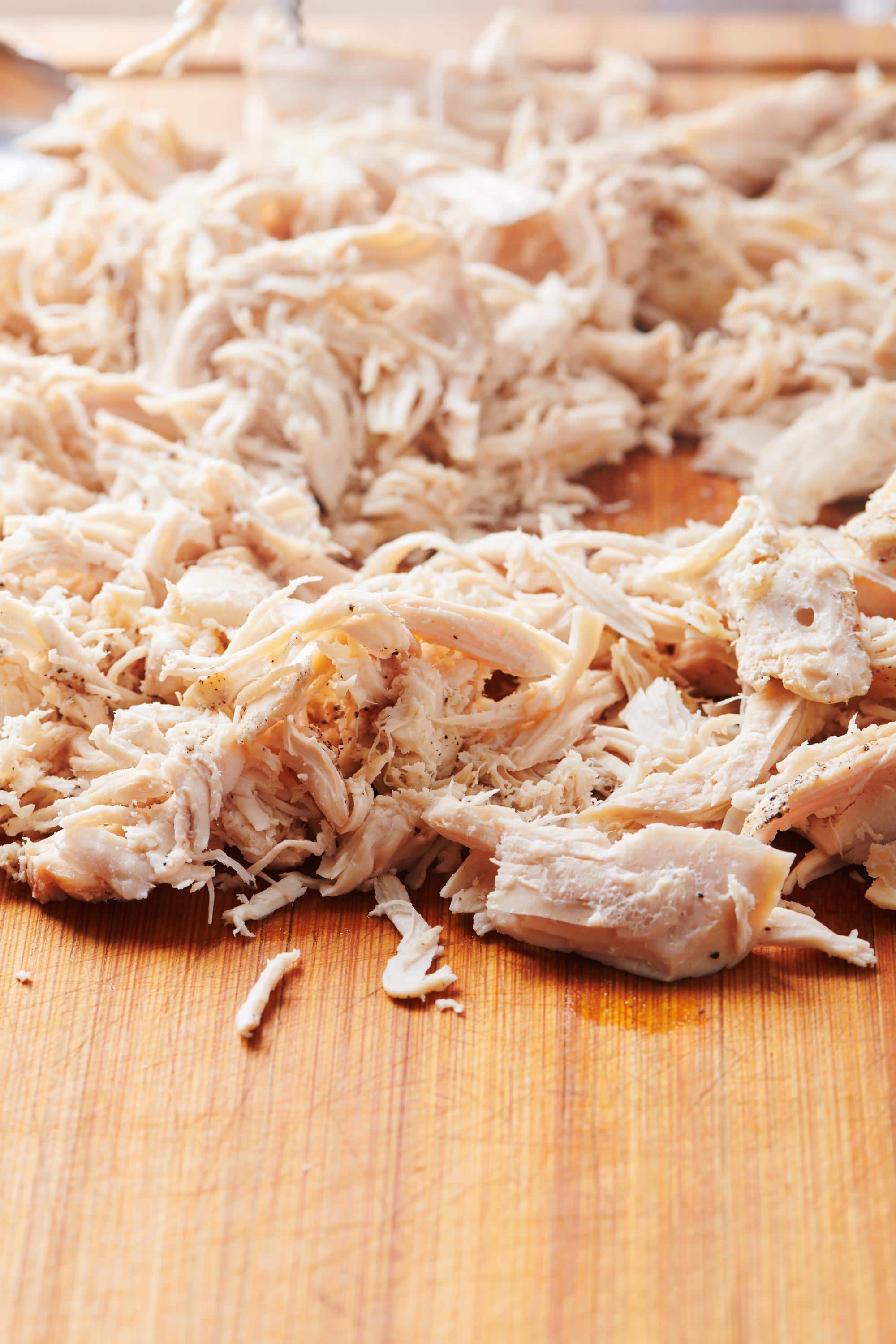 Shredded chicken on a wooden surface.