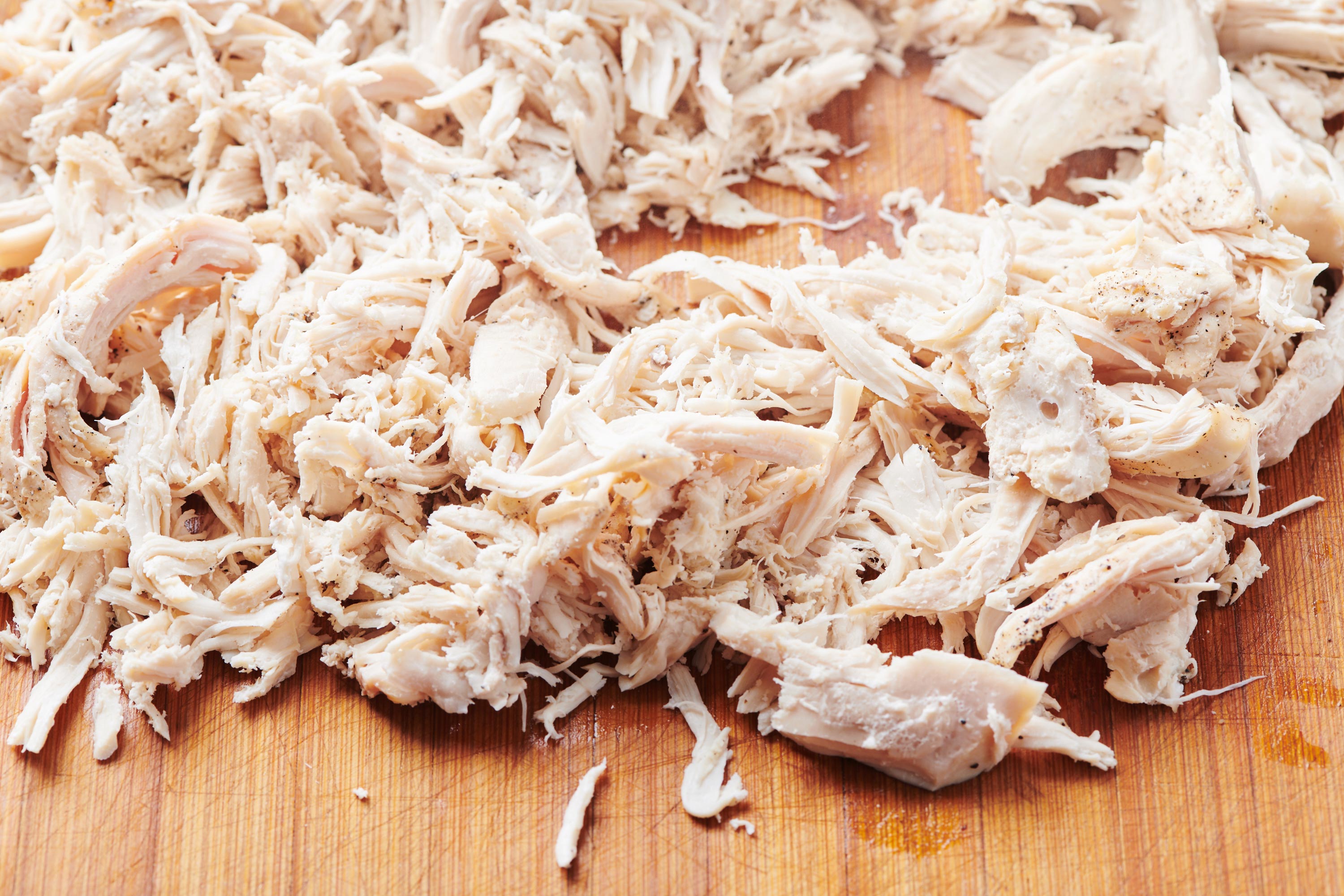 Shredded chicken on a cutting board.