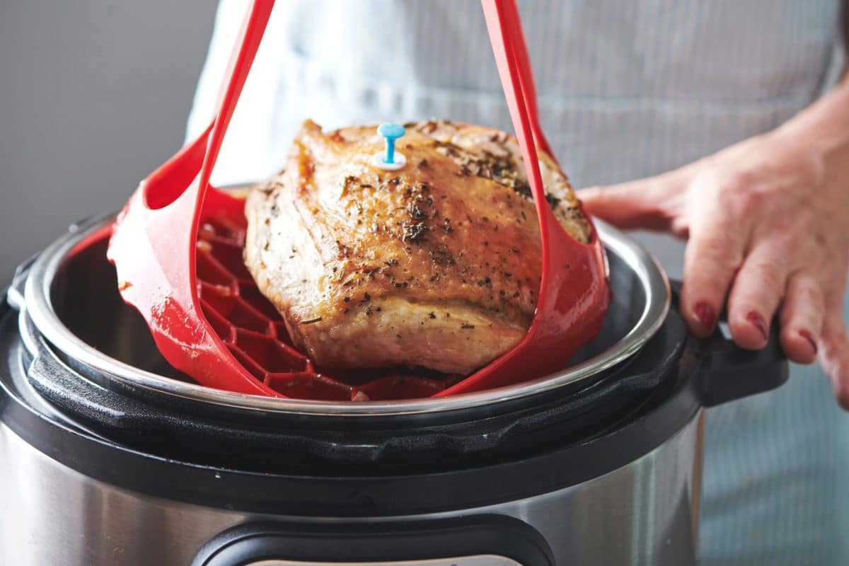 Red sling pulling a Turkey Breast out of an Instant Pot.
