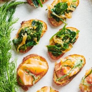 Caramelized Onion and Spinach Crostini on a plate with other crostini.
