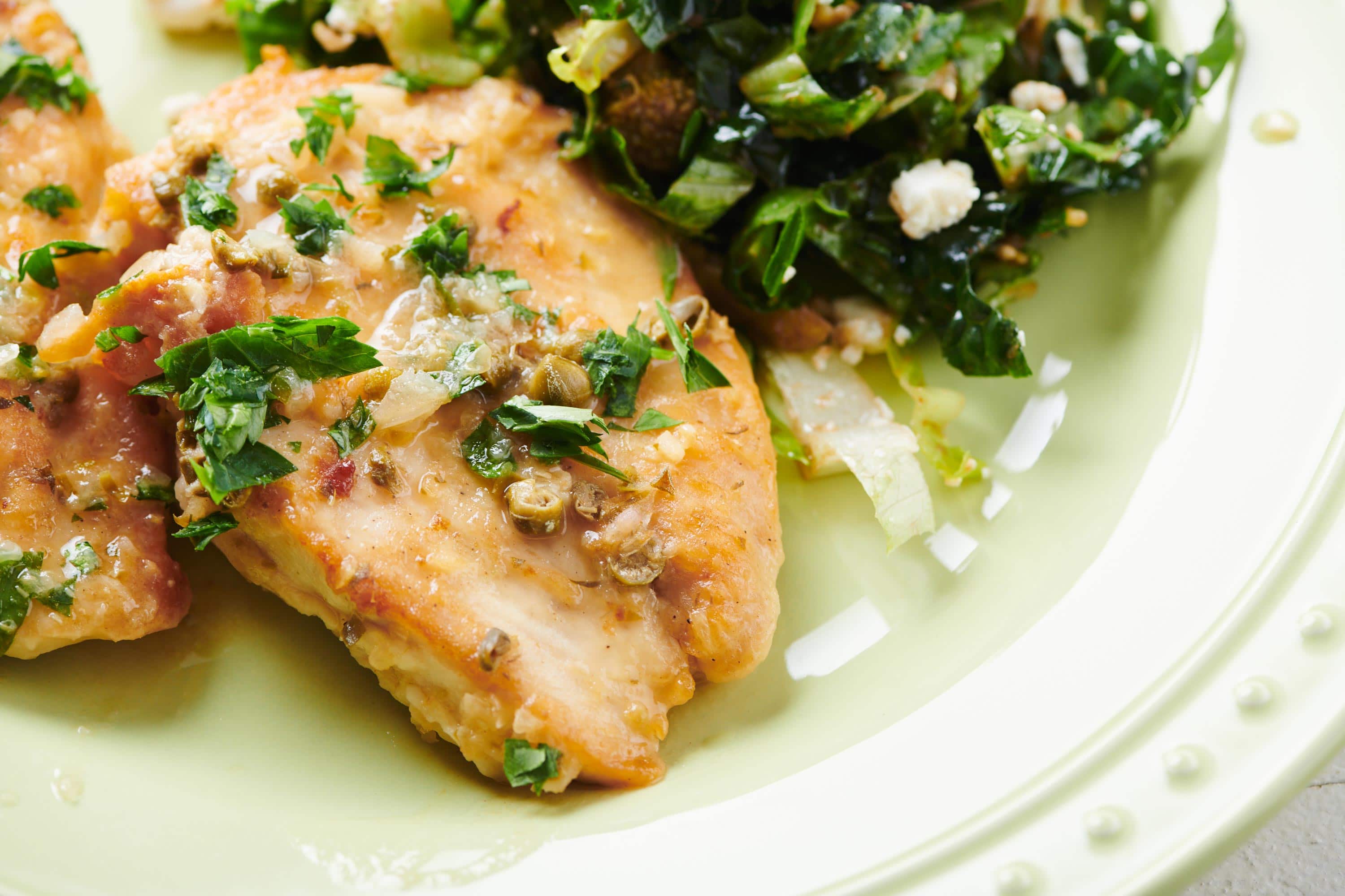 Chicken Piccata on a light green plate.